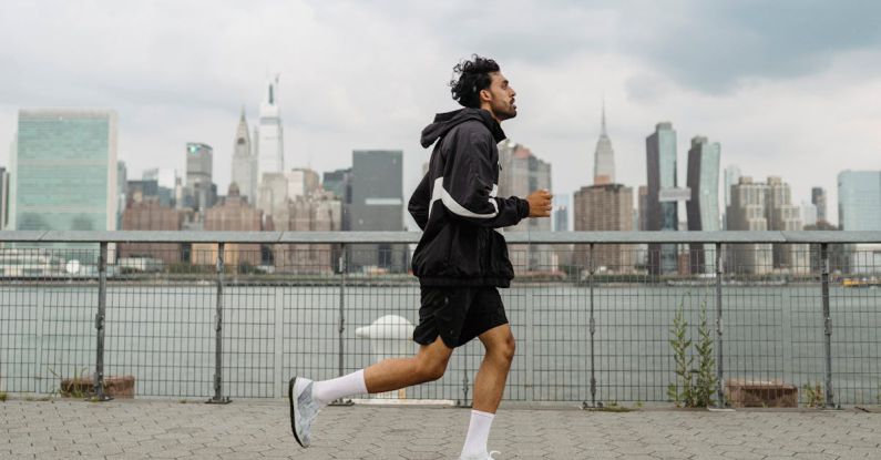 Urban Sports - Man Wearing Jacket and Black Shorts Running in the City