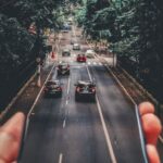 Car Sharing - Forced Perspective Photography of Cars Running on Road Below Smartphone