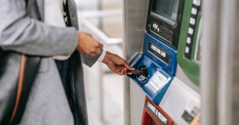 Transport Accessibility - Side view of crop unrecognizable female in stylish clothes using credit card while buying metro ticket via electronic machine