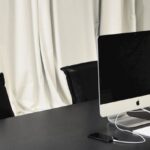 Public Spaces - Black and white of contemporary computer placed on table in simple contemporary workplace of office