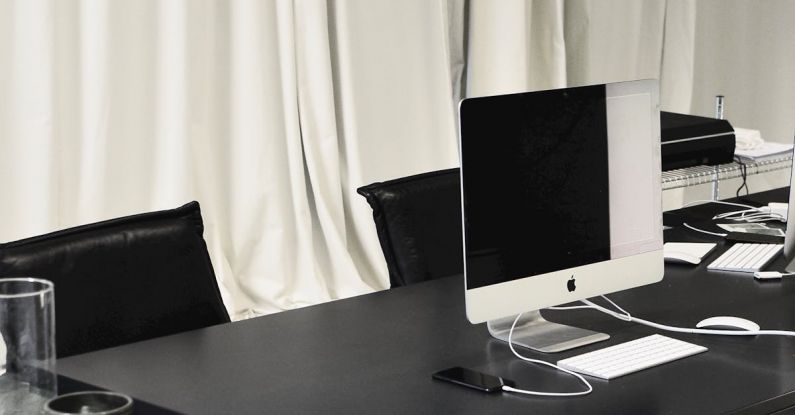 Public Spaces - Black and white of contemporary computer placed on table in simple contemporary workplace of office