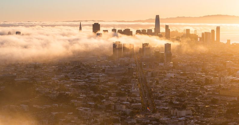 Gentrification - A city is covered in fog and the sun is rising