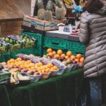 Local Food - Woman Standing in Front of Assorted Fruits Displayed