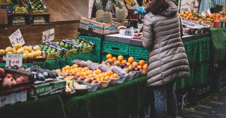 Local Food - Woman Standing in Front of Assorted Fruits Displayed