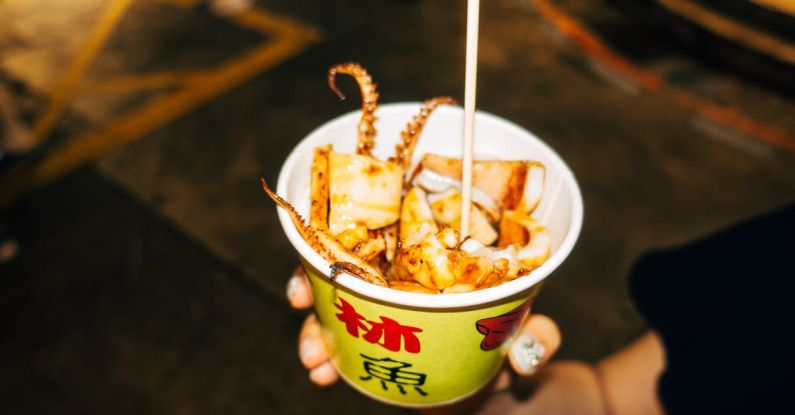 Culinary Innovation - A person holding a cup of food with a straw