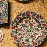 Artisan Markets - Ceramic decorative handmade plates with various ornaments hanging on stone wall in Morocco